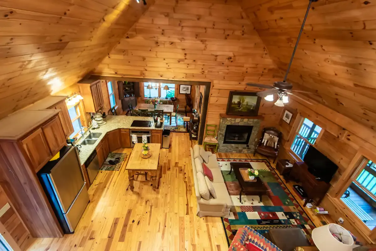 A view from the upstairs, looking down on the dining room, living area, and kitchen.